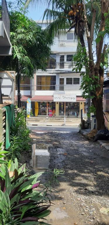 a building with a palm tree in front of a street at Angel and Marie's Basic ACroom for 2-4 pax in San Juan