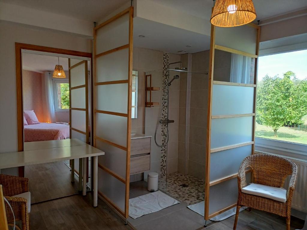 a bathroom with a shower and a desk and a table at Les chambres du Vert Galant Rez de jardin in Verlinghem