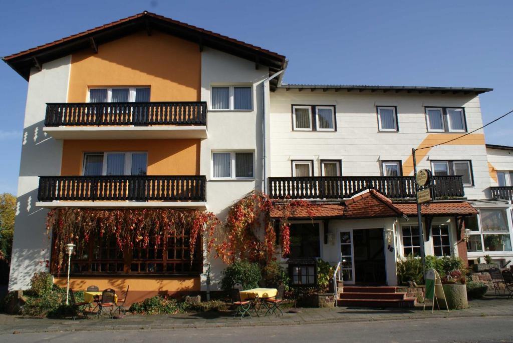 a large white building with a balcony at Gasthaus Pension Schumbert in Bullau