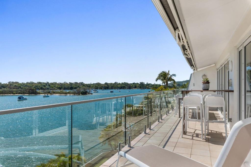 a balcony with chairs and a view of the water at Commodore 7 80 Noosa Parade in Noosa Heads