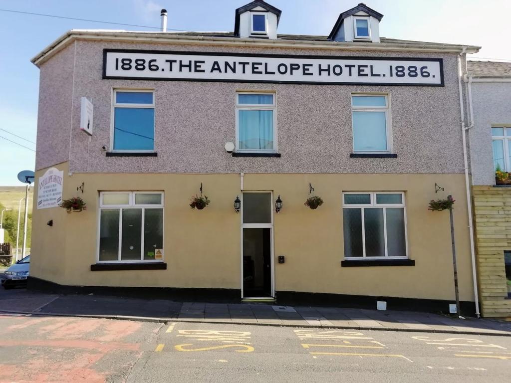 a building with a sign that reads the antiglippi hotel at The Antelope Hotel in Merthyr Tydfil