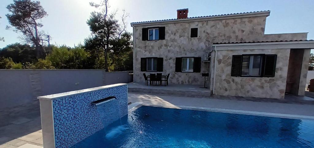 una casa y una piscina frente a una casa en Villa-Sana, en Vir