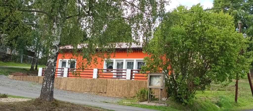 an orange house with a fence in front of it at Penzion U Kapličky 