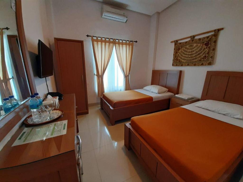 Postel nebo postele na pokoji v ubytování The Sriwijaya Hotel - Halal Hotel