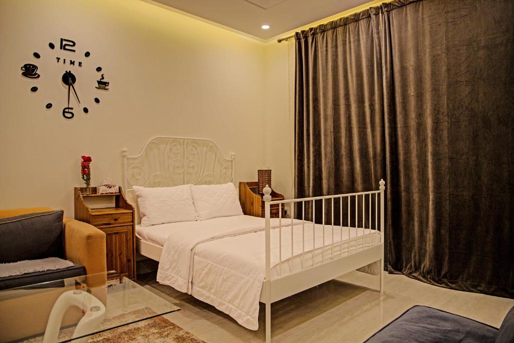 a bedroom with a crib and a clock on the wall at Super OYO 629 Home Lux Suite in Riyadh