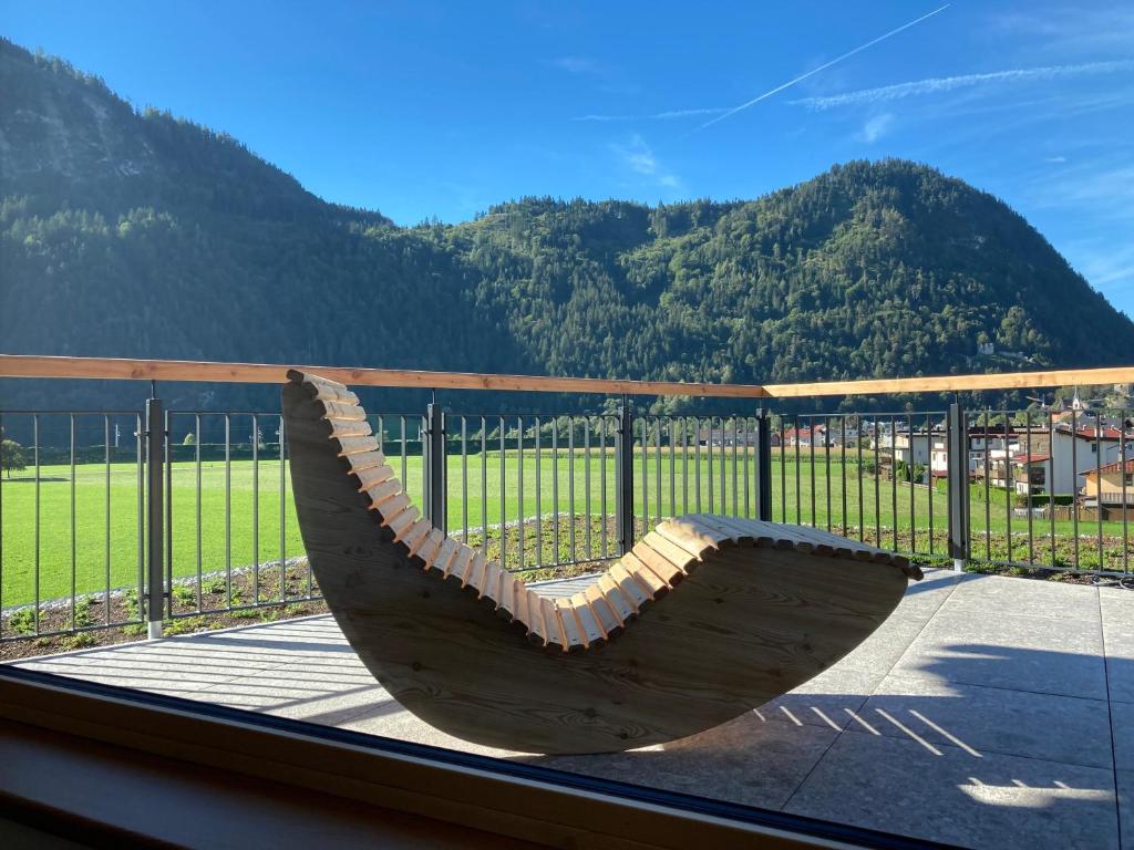 un banco sentado en un balcón con vistas a la montaña en Zeit.Glück Appartements, en Radfeld