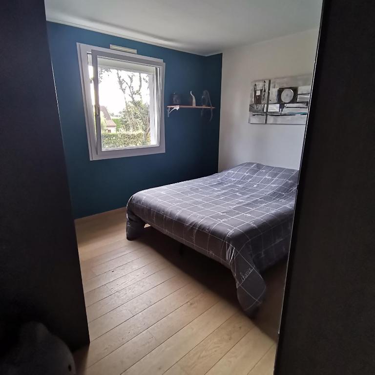 ein Schlafzimmer mit einem Bett in einem Zimmer mit einem Fenster in der Unterkunft Appartement dans habitation privée avec piscine in La Milesse