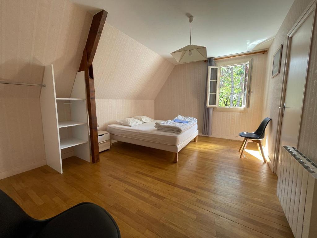 sypialnia z łóżkiem, drabiną i krzesłem w obiekcie Villa piscine 15 Personnes w mieście Brouchaud