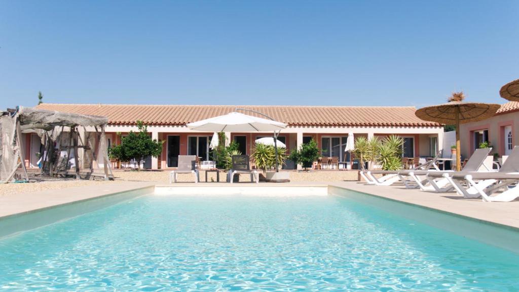 - une piscine avec des chaises et des parasols dans un complexe dans l'établissement L´oliveraie, à Perpignan