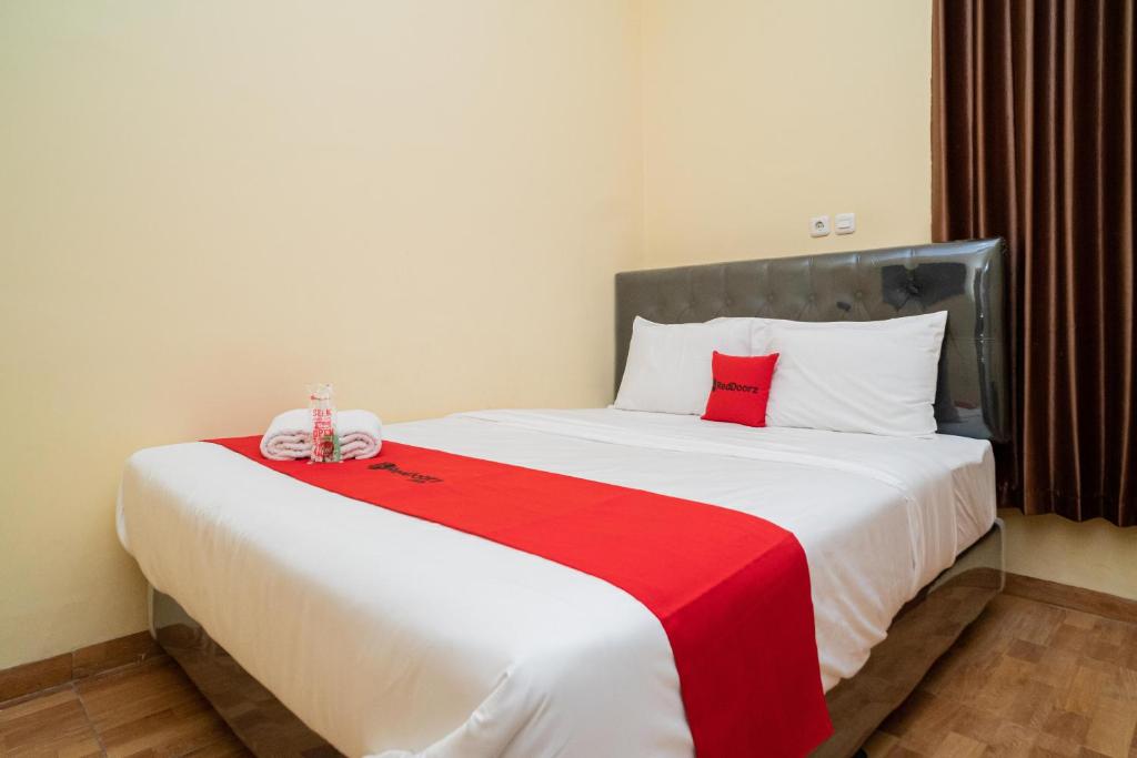 Postel nebo postele na pokoji v ubytování RedDoorz Syariah near Jembatan Merah Plaza