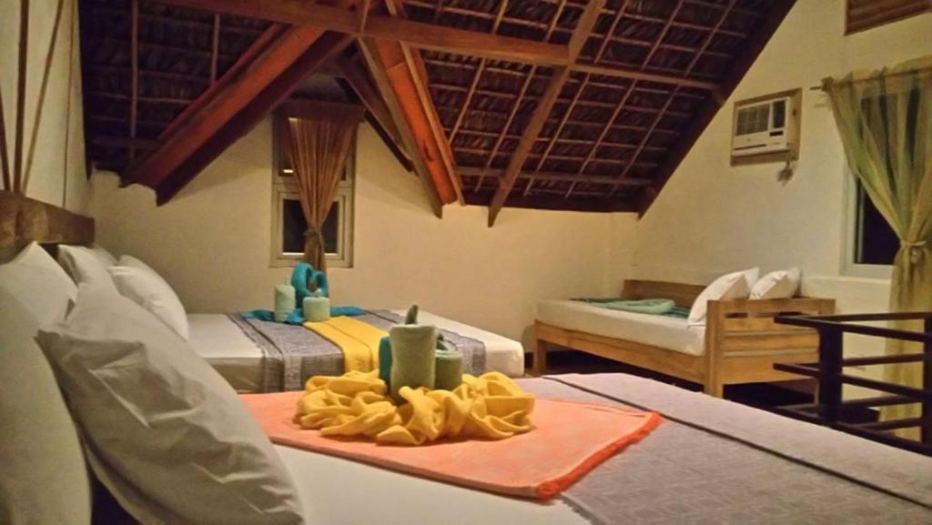 Zimmer mit 2 Betten und einem Tisch mit einem Tablett mit Essen in der Unterkunft Alta Vista Ilocandia Inc. in Pagudpud