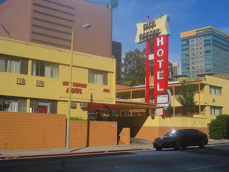 une voiture garée devant un immeuble avec un panneau dans l'établissement City Center Hotel Los Angeles, à Los Angeles