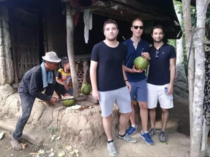 un groupe d'hommes debout devant un bâtiment où se trouvent des melons dans l'établissement Bali Livin,tayehomestay, à Banjarangkan