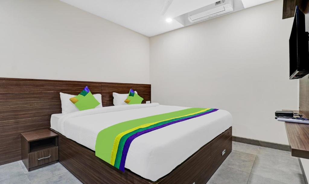 sypialnia z dużym łóżkiem z tęczowym kocem w obiekcie Treebo Trend Purple Orchid Boutique w mieście Bengaluru