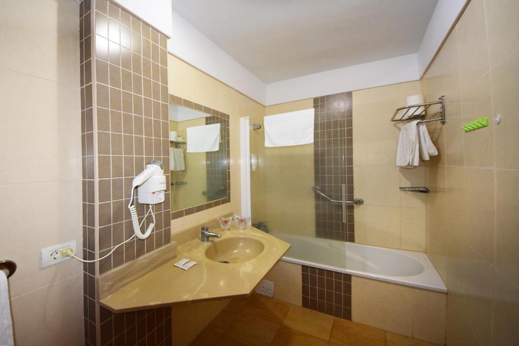 a bathroom with a sink and a shower and a tub at Skyview Hotel Tenerife in Puerto de la Cruz