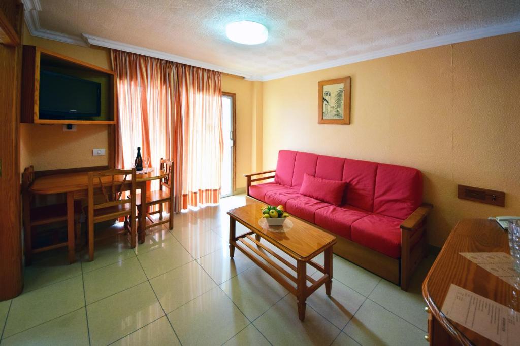 a living room with a red couch and a table at Skyview Hotel Tenerife in Puerto de la Cruz
