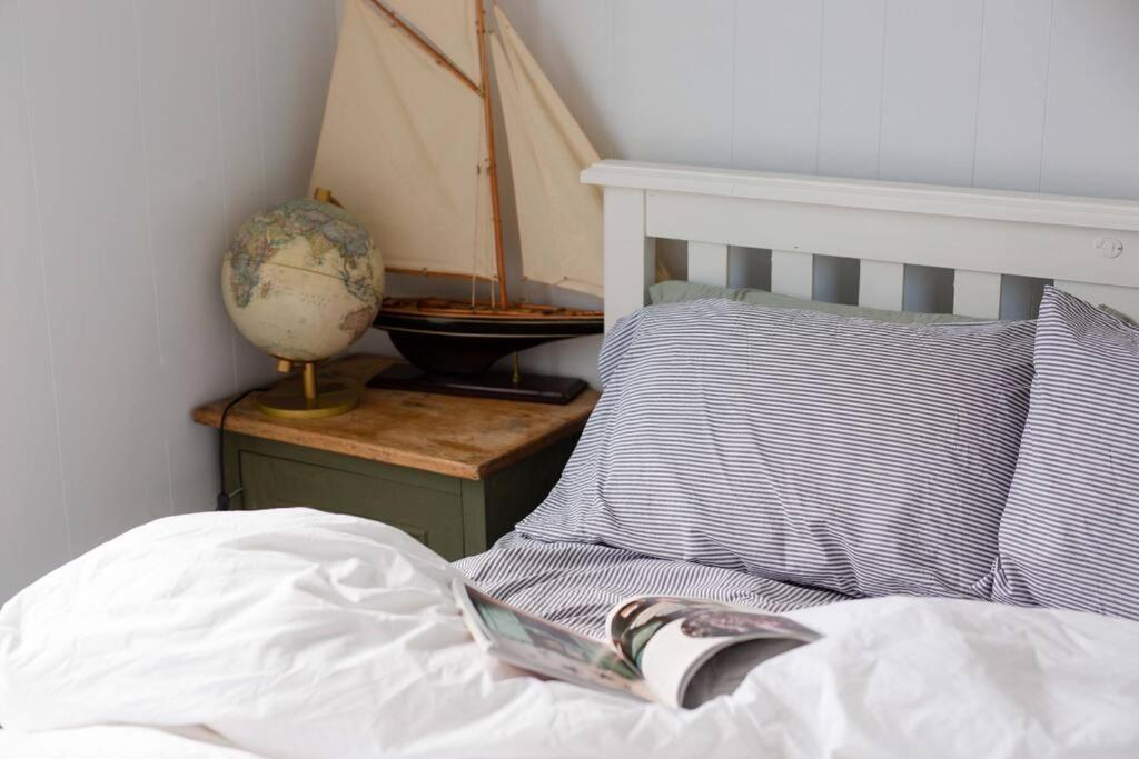 un libro appoggiato sopra un letto con un cuscino di Little Beach House Bicheno a Bicheno