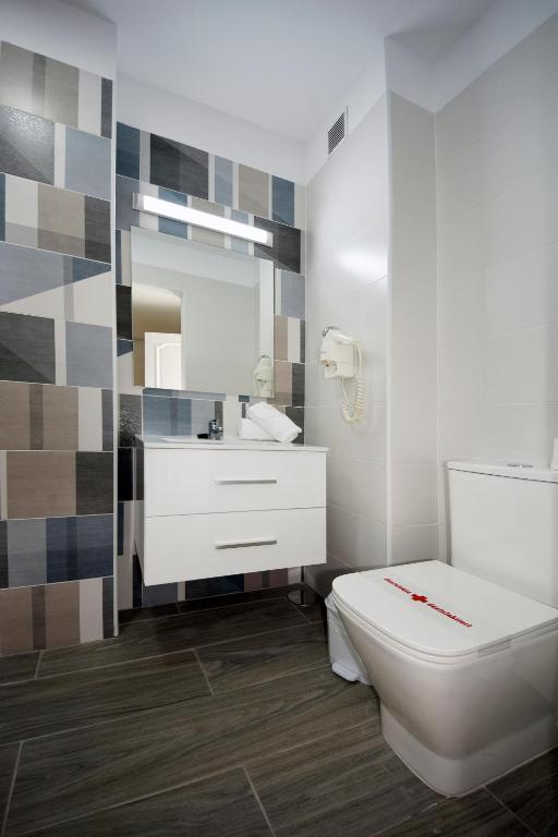 a bathroom with a white toilet and a sink at Skyview Hotel Tenerife in Puerto de la Cruz