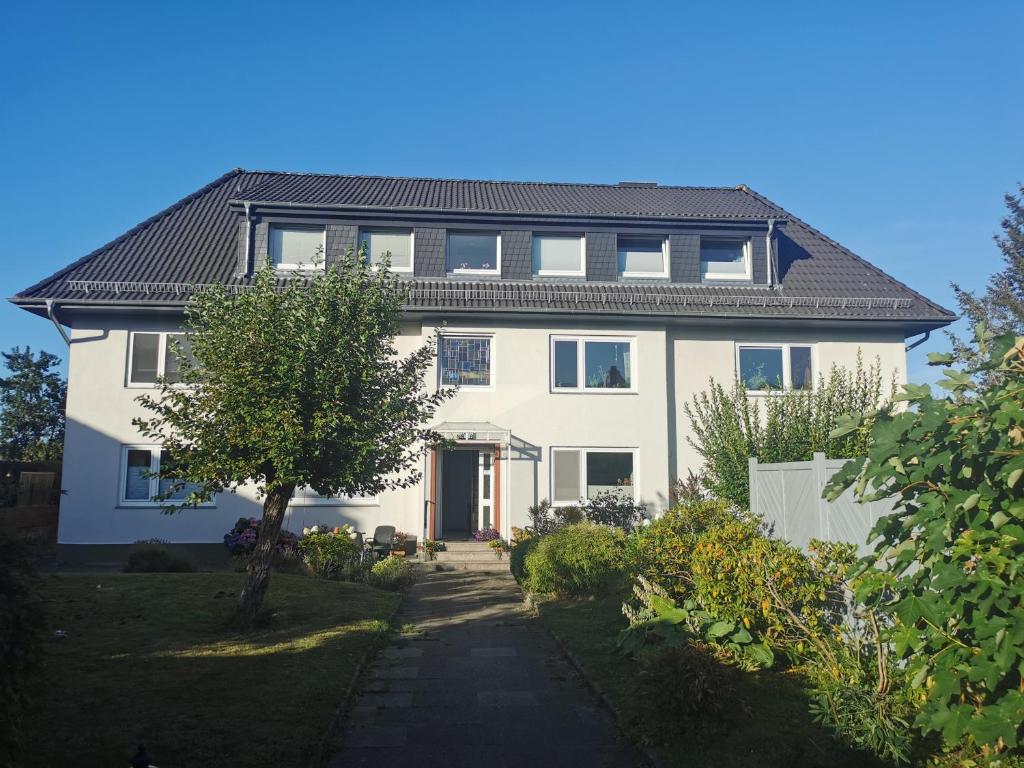 a white house with a black roof at Gemütliche Gästewohnung in ruhiger Lage in Kronshagen