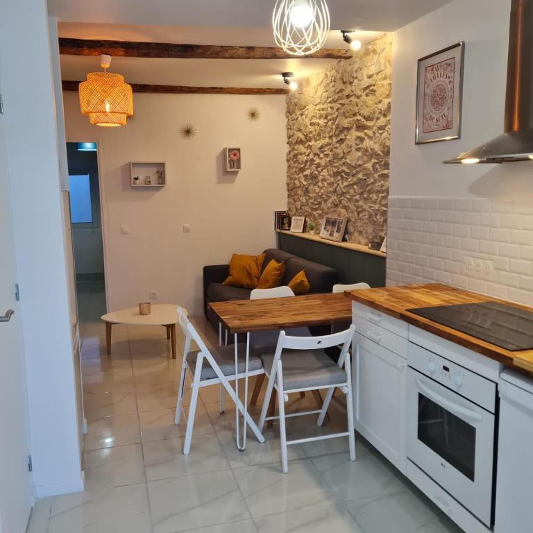 una cucina e un soggiorno con un tavolo e un divano di Sète, T2 cosy et atypique, Jardin Château d'eau, centre ville a Sète