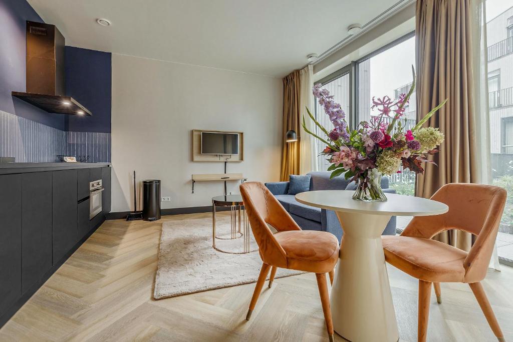 een woonkamer met een tafel met een vaas met bloemen bij Bens The Highdocks in Amsterdam
