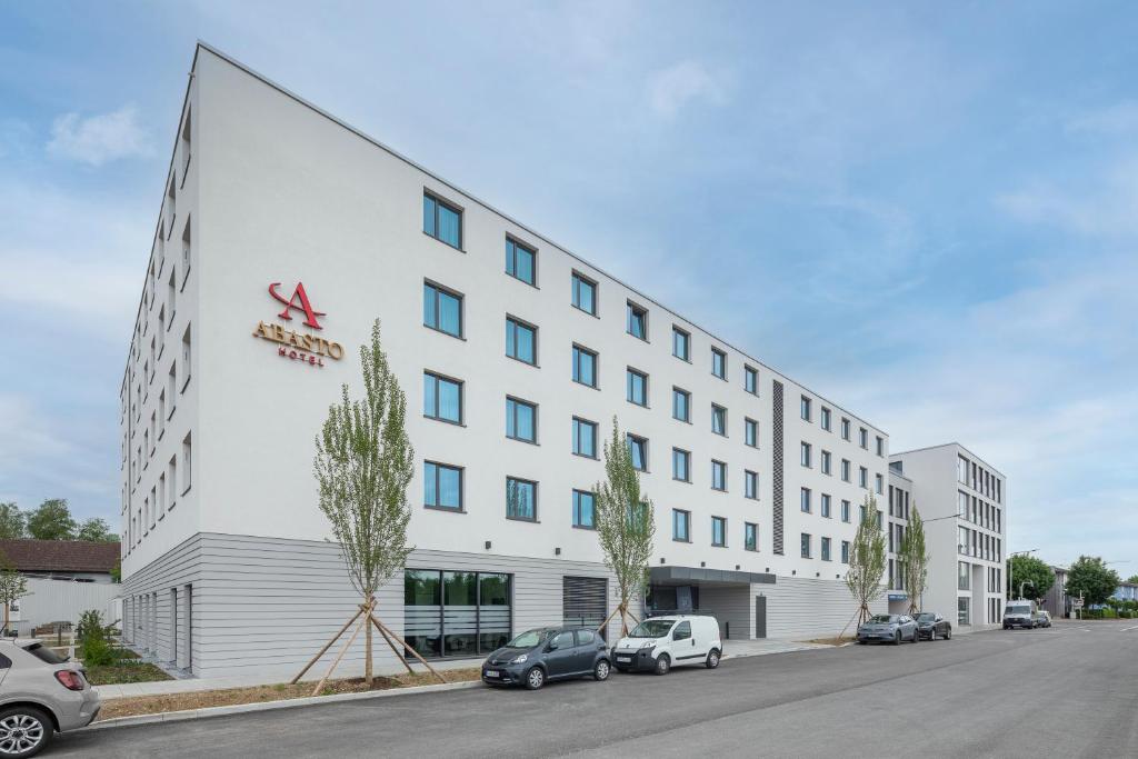 een kantoorgebouw met auto's ervoor geparkeerd bij Abasto Hotel Dachau in Dachau