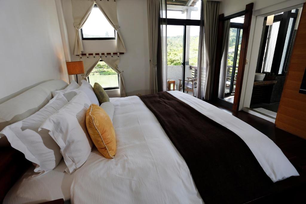 a bedroom with a large white bed with pillows at Mudanwan Villa in Mudan