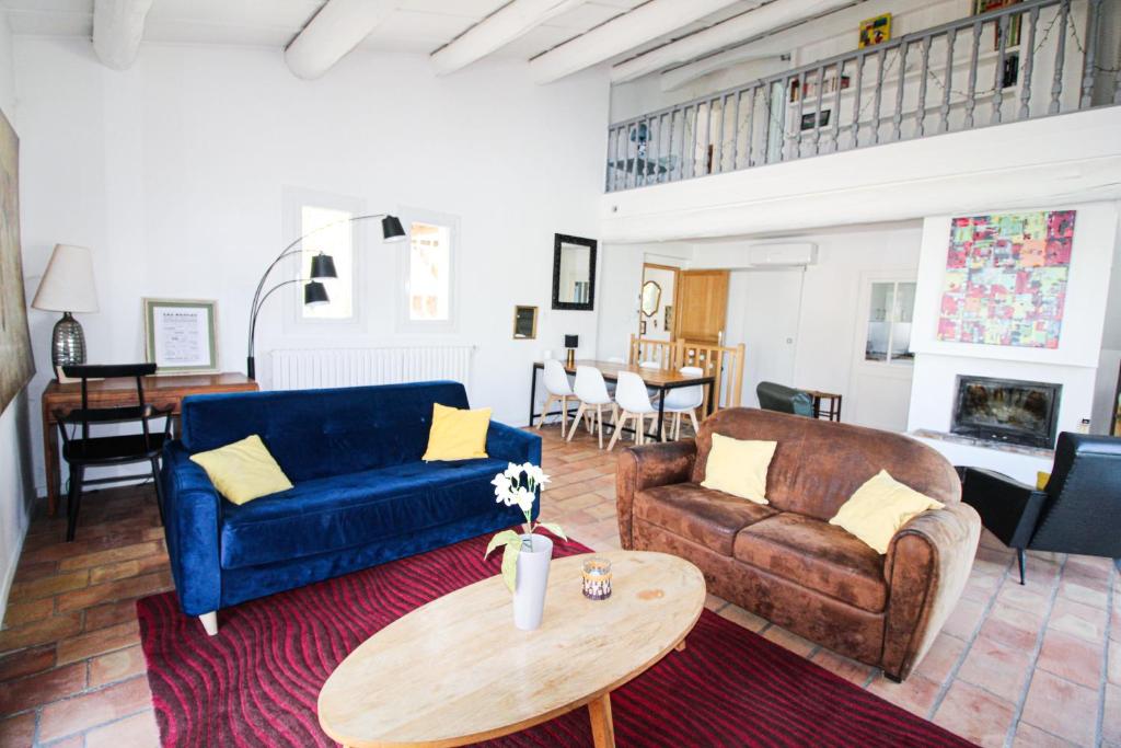 uma sala de estar com um sofá azul e uma mesa em La Maison Joffre - Chez Marcel - Vue Fort St André - Piscine éco em Villeneuve-lès-Avignon