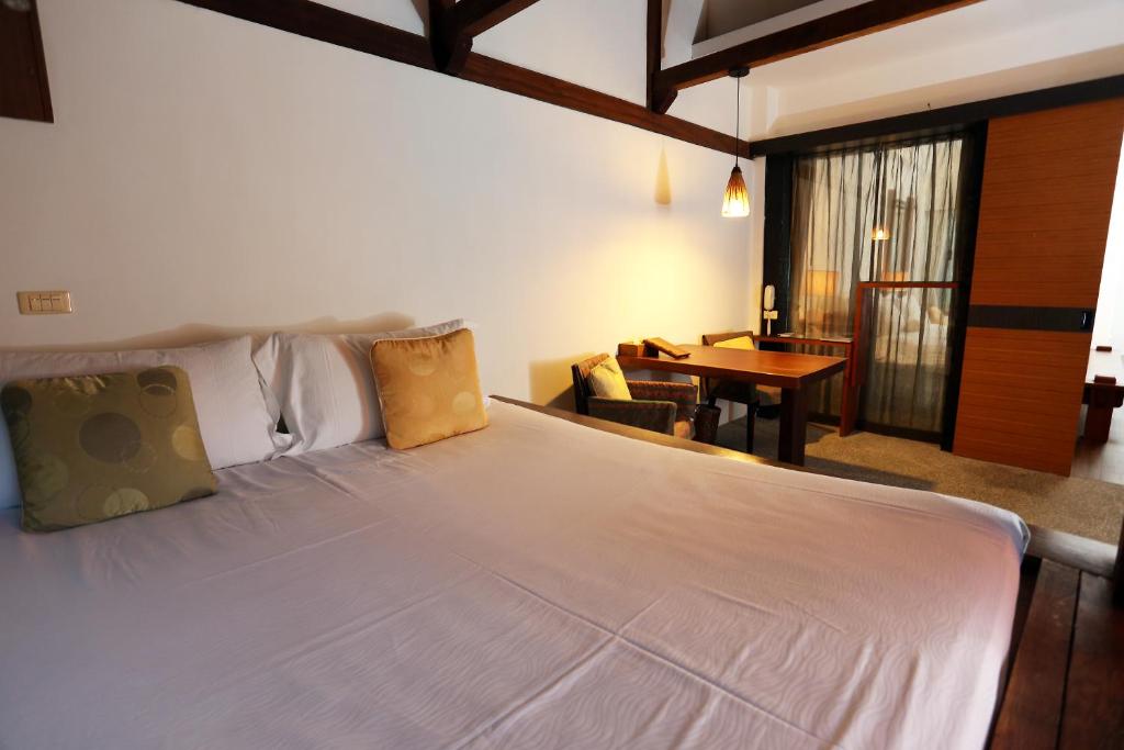 a bedroom with a large white bed and a table at Mudanwan Villa in Mudan