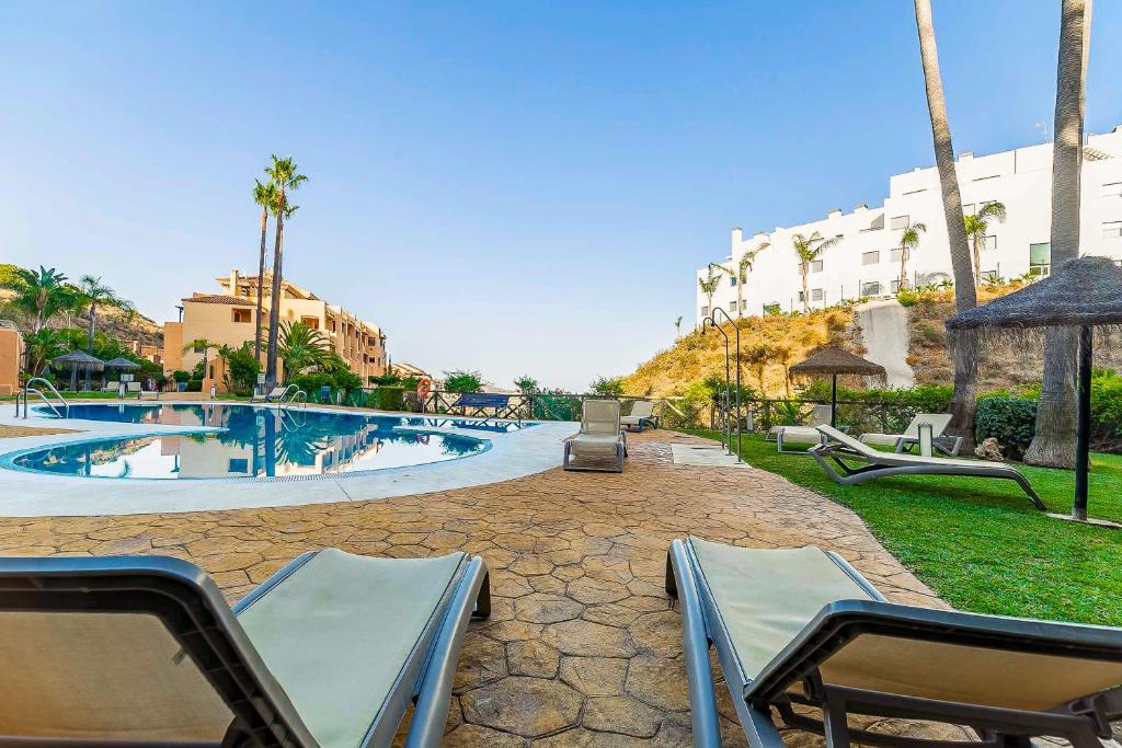 een resort met een zwembad met ligstoelen bij 80-Cozy Apartment in La Cala de Mijas! in Málaga