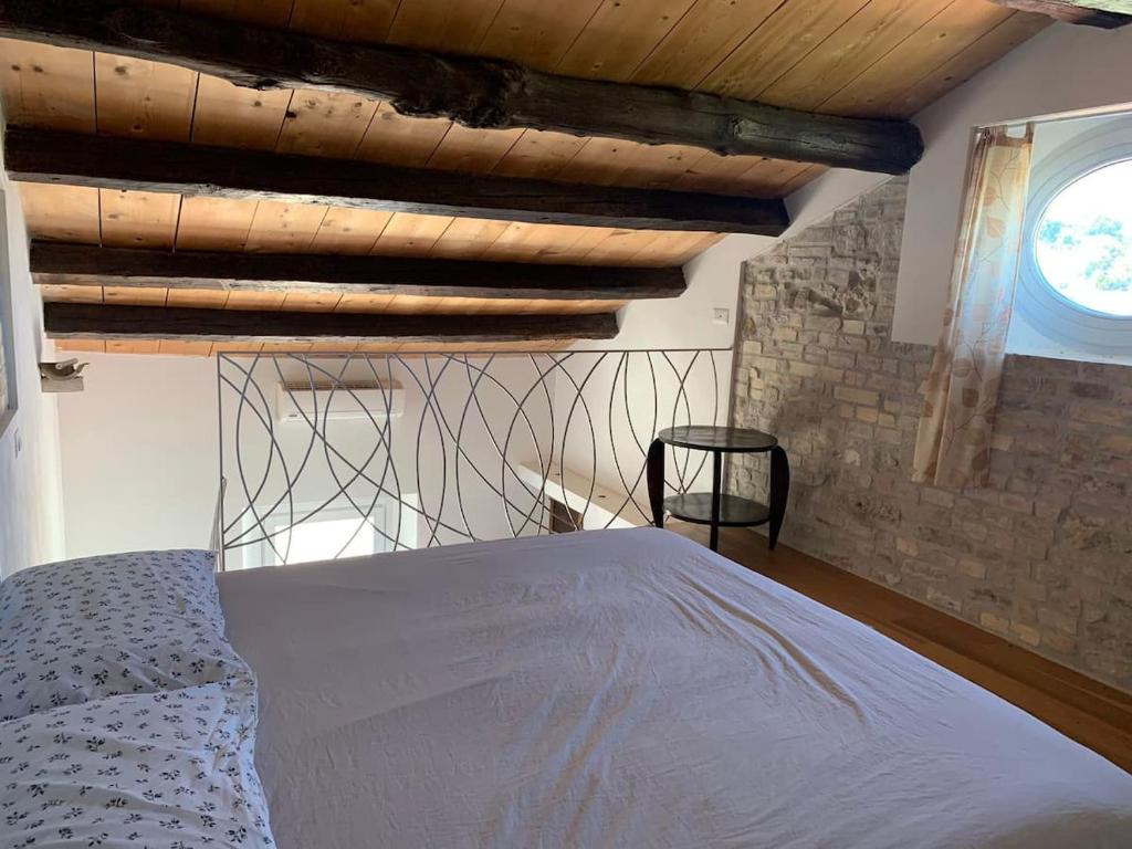 een slaapkamer met een bed en een houten plafond bij Lu Prete in Campofilone