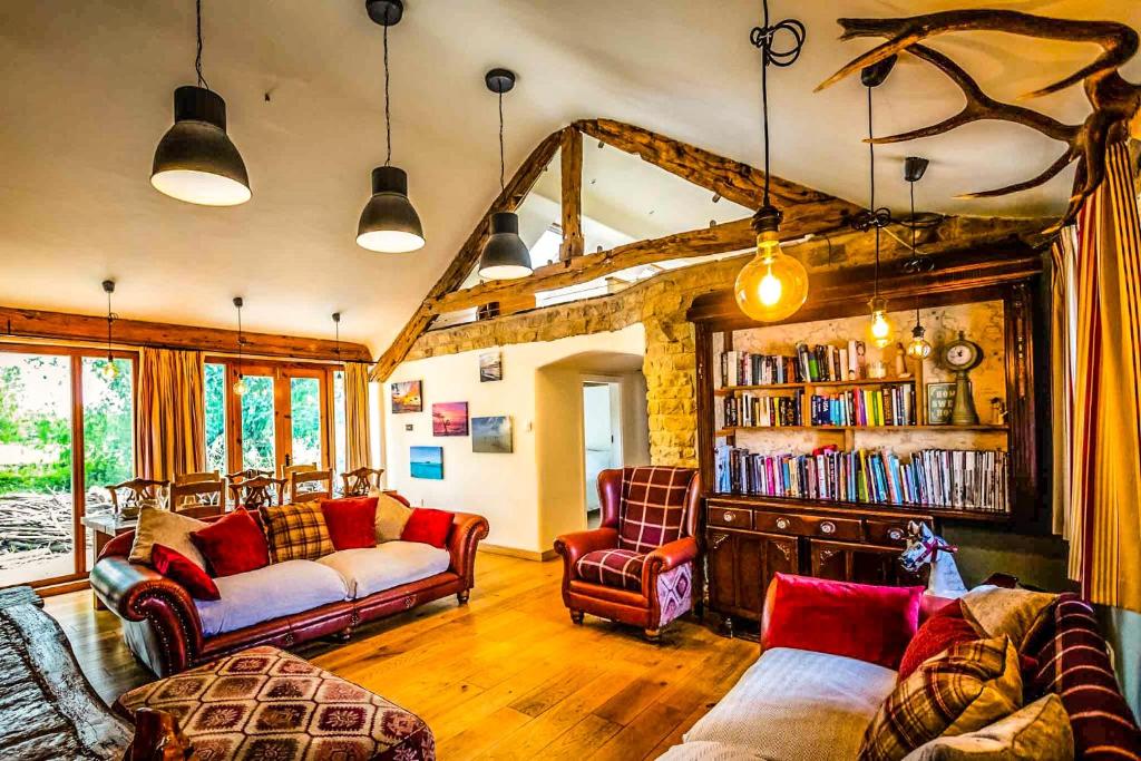 a living room with two couches and a book shelf at Bence Farm Yorkshire, barn conversion with hot tub karaoke great views between leeds and sheffield 