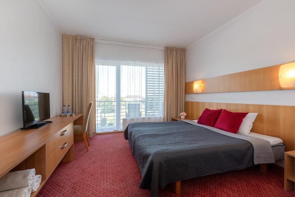 a hotel room with a bed and a television at Raadimõisa Hotell in Tartu