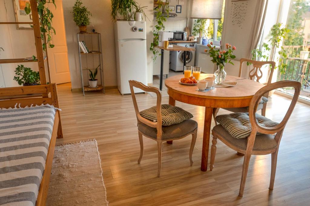 una mesa de comedor con 2 sillas y una mesa con bebidas. en Heart of Mitau, en Jelgava
