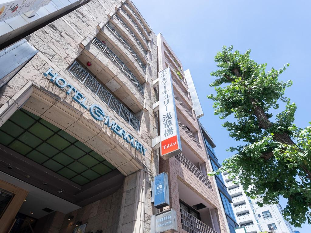 un bâtiment avec un panneau sur son côté dans l'établissement Tabist Hotel Mercury Asakusabashi, à Tokyo