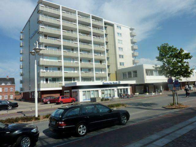 un coche negro estacionado frente a un gran edificio en App-Seeblick-Hanseatenhaus, en Westerland