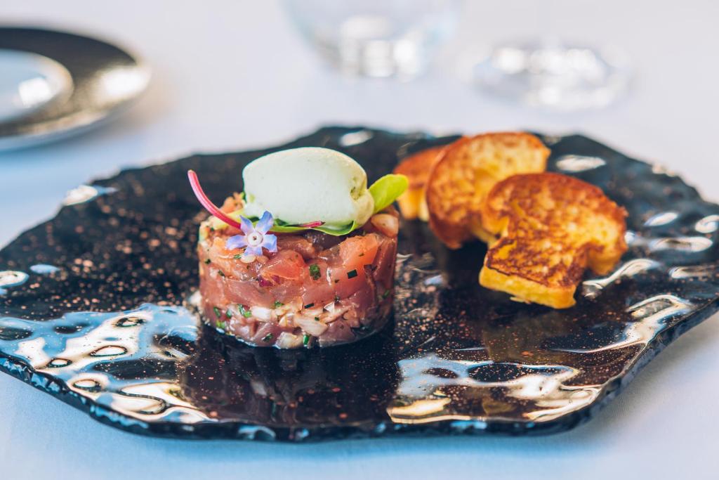 a black plate with a dessert on a table at Iberostar Heritage Grand Mencey in Santa Cruz de Tenerife