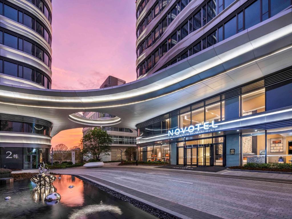 a large building with a pond in front of it at Novotel Shanghai Caohejing in Shanghai