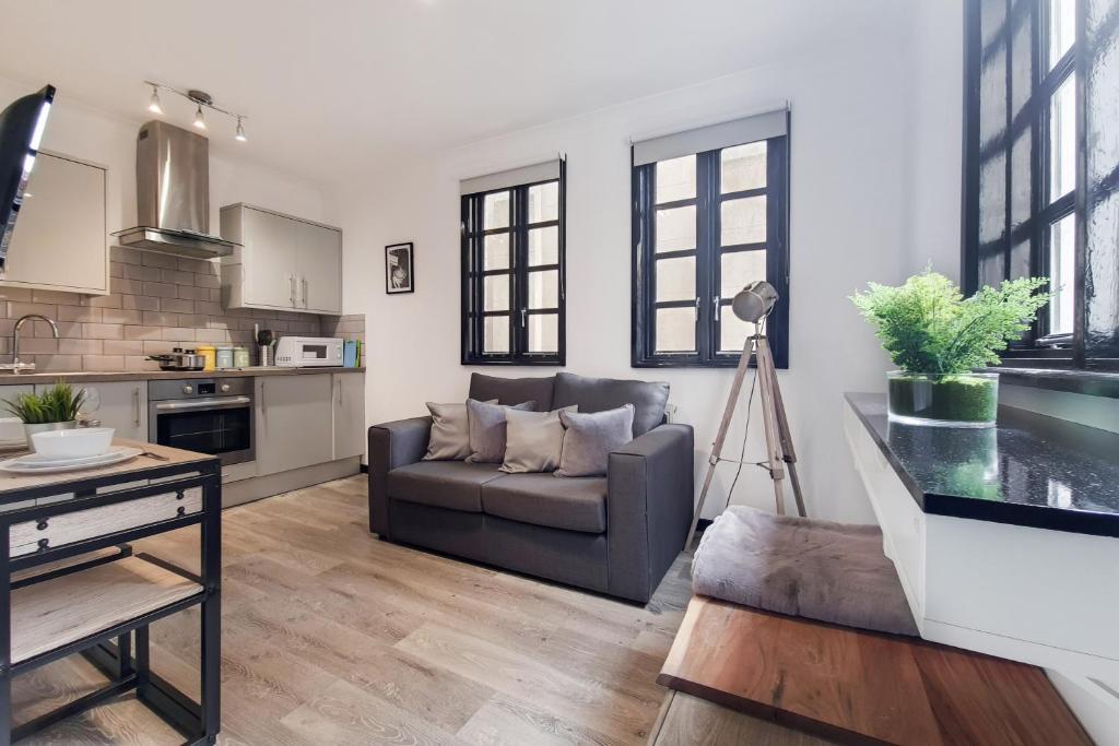 a living room with a couch and a kitchen at Langdon Brooks Apartments in London