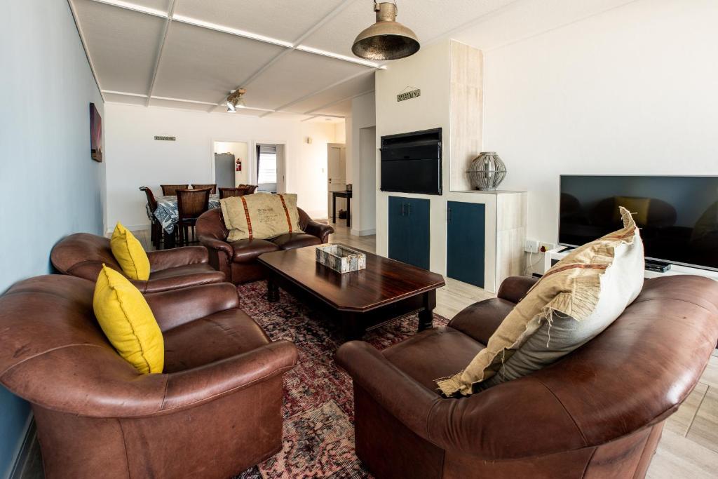 sala de estar con sofás de cuero y mesa en NORDSTRANDPARK 26 en Swakopmund