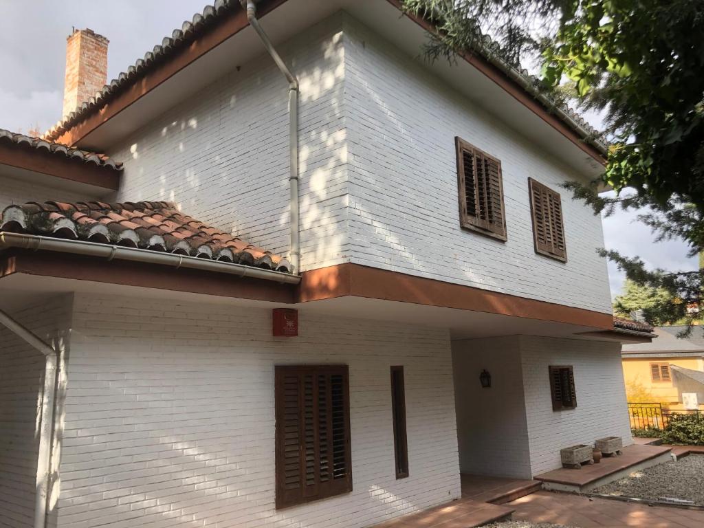 a white building with a red roof at Estupenda Villa con piscina a 5 minutos del centro de Granada in Granada