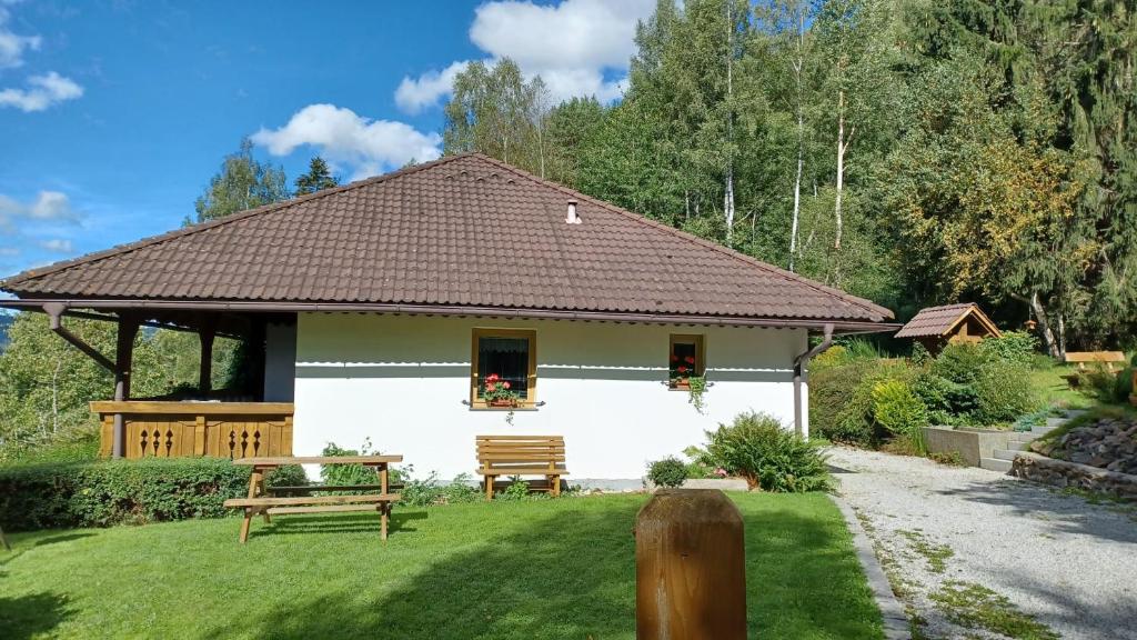 ein weißes Haus mit einer Bank im Hof in der Unterkunft Zátoň č.15 in Lenora