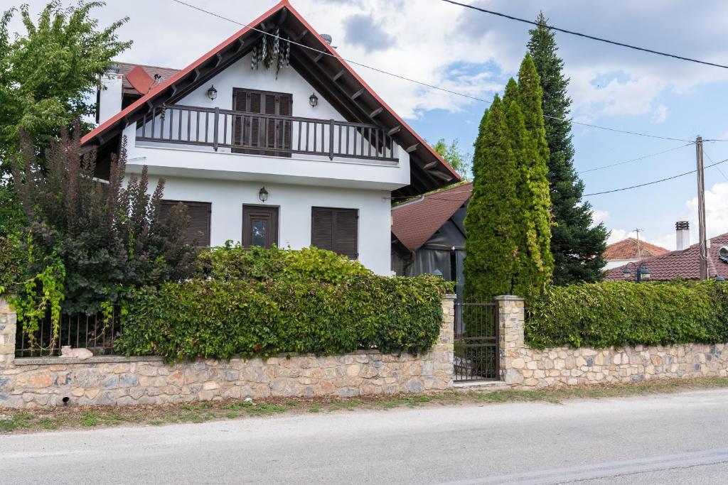 a white house with a stone wall and trees at Luxury Traditional Villa in Khiliódhendron