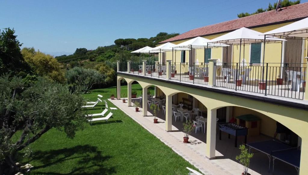 een gebouw met stoelen en tafels op een gazon bij Agriturismo Monte Maggio in Lapedona