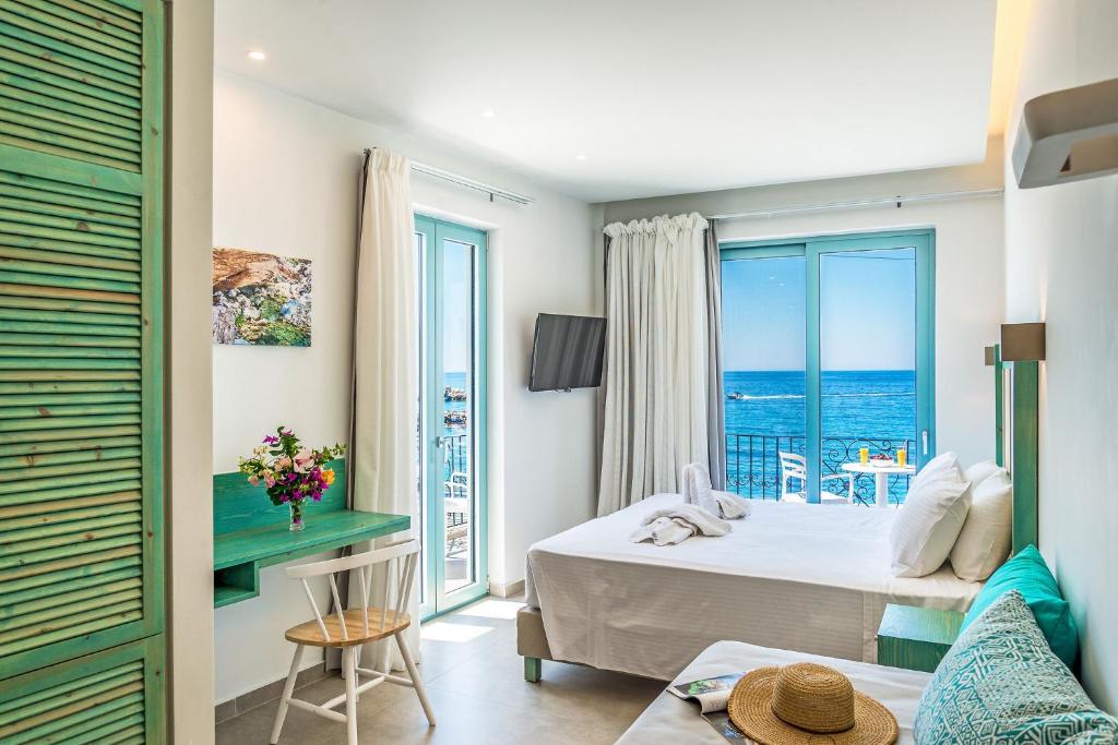 a hotel room with a bed and a view of the ocean at Samaria by the Sea in Hora Sfakion