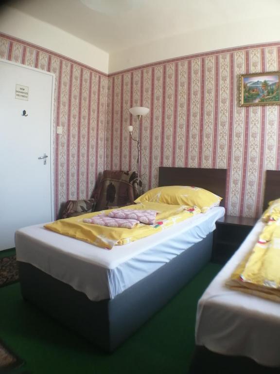 A bed or beds in a room at Jocó Panzió