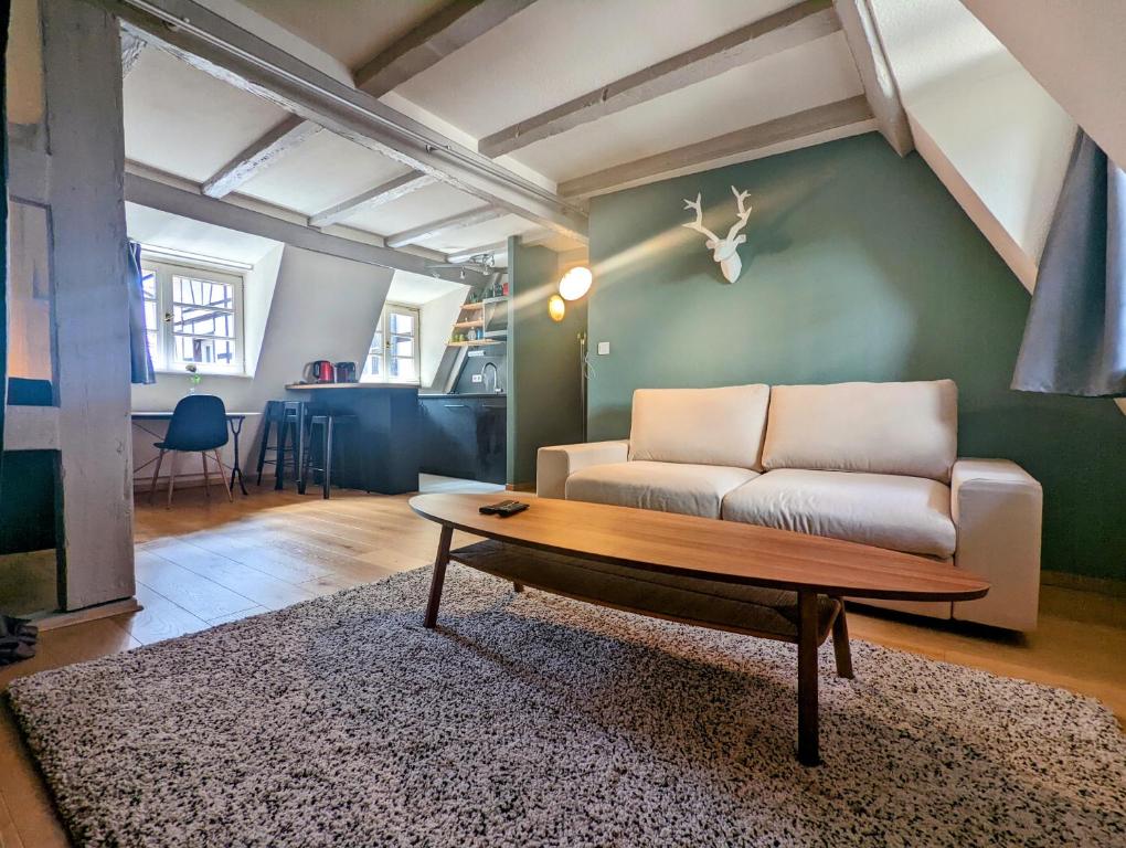 ein Wohnzimmer mit einem Sofa und einem Tisch in der Unterkunft CityCosy Strasbourg - Authentique Batelier in Straßburg