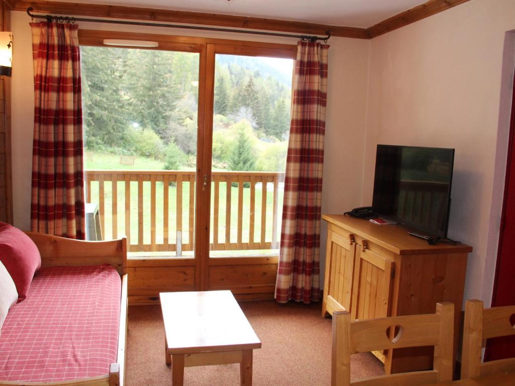 a living room with a television and a balcony at Appartement Lanslebourg-Mont-Cenis, 3 pièces, 6 personnes - FR-1-508-234 in Lanslebourg-Mont-Cenis