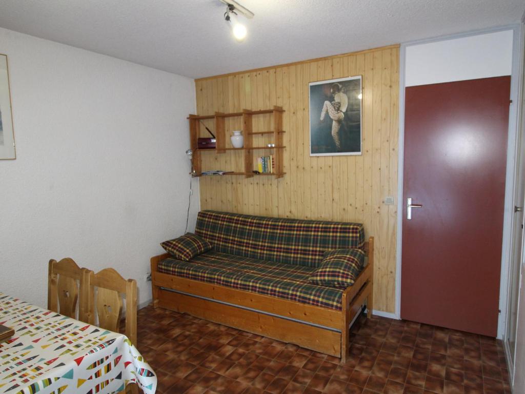 a bedroom with a bed in a room with a table at Appartement Lanslevillard, 2 pièces, 4 personnes - FR-1-508-231 in Lanslebourg-Mont-Cenis