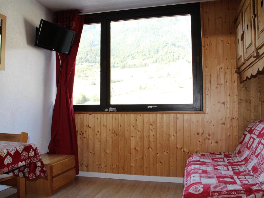 a room with a window and a bed and a tv at Studio Lanslevillard, 1 pièce, 2 personnes - FR-1-508-235 in Lanslebourg-Mont-Cenis